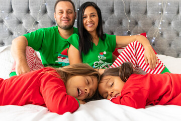 Cute family lying in their bed at christmas