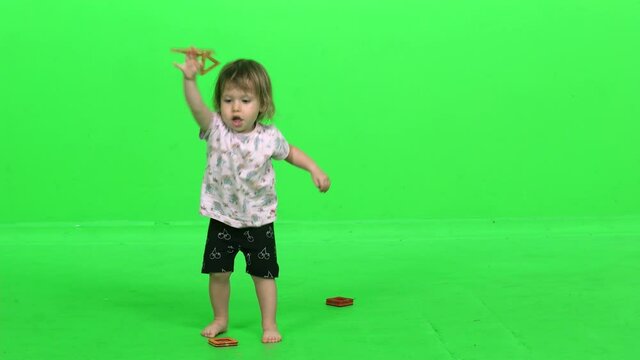 Cute toddler girl throwing magnets game over green screen. Happy and cheerful playing.