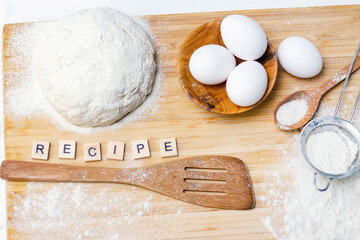 making dough for bread or homemade baked goods. ingredients on a wooden table. inscription: recipe