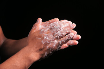 young man washing hands with soap warm water isolated on black 