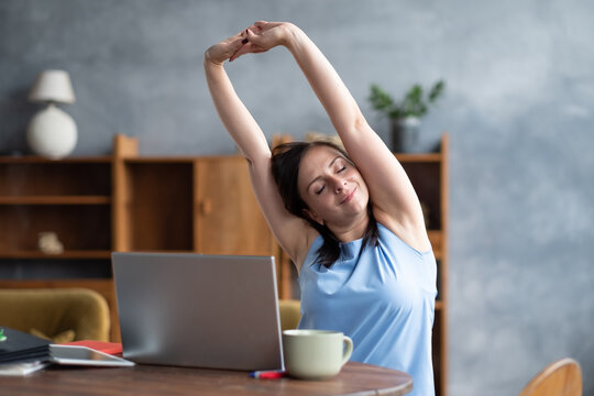 Caucasian woman performing a side stretching exercise for the spine working at home.