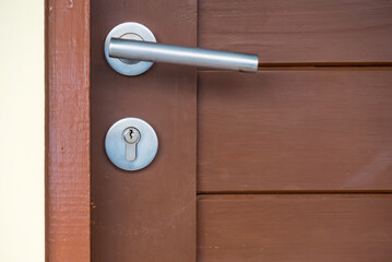 Lock and door handle on solid wooden door.