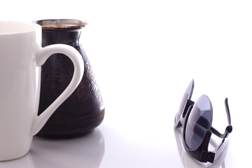 cezve with white mug, sunglasses on white background