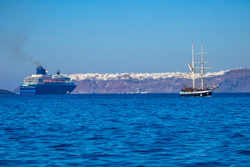 Obraz premium Old Sailing Ship and Modern Cruise Ship off the Coast of Santorini