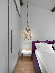 detail of the interior of a modern bedroom on the bedside table with an amazing chandelier