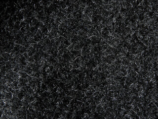Black natural wool carpet texture background. Texture of dark wool fabric. fragment of a grey furry coat © Andrey