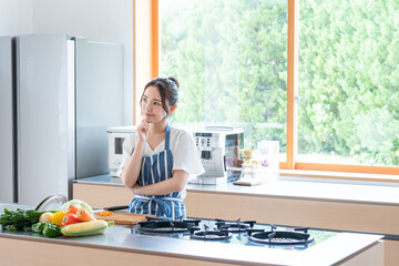 キッチンで料理する若い女性