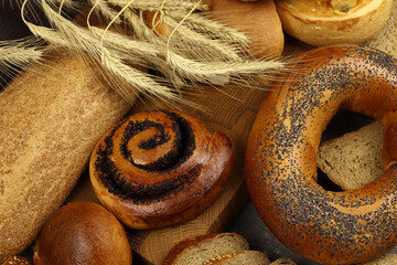Bakery product assortment with loaves of bread, rolls, bagels and wheat ears