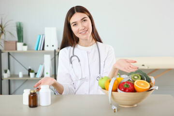 young doctor nutritionist in his office demonstrates the concept of healthy eating. Help with weight control