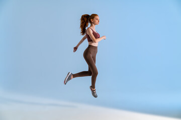 Photo of athletic focused sportswoman jumping while working out