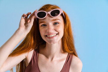Photo of redhead woman in sunglasses smiling and looking at camera