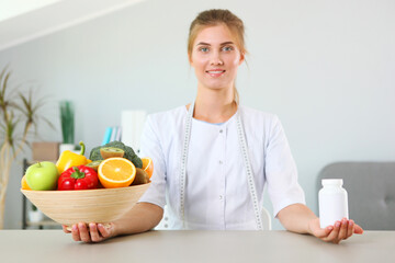 young doctor nutritionist in his office demonstrates the concept of healthy eating. Help with...