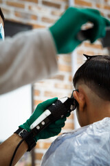A young boy getting his hair cut at barber shop, barber shop rear view