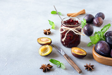 Plum jam and ingredients for its preparation: plums, cinnamon, star anise and mint. Autumn preparations