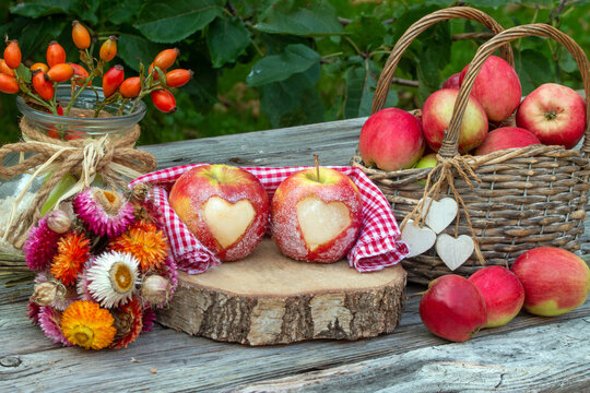Rote &Auml;pfel mit Herz rustikal auf Holz als Dekoration f&uuml;r den Herbst