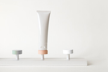 Mockup cosmetic tube stand on pedestal on white background, front view. Skin care concept. Podium with moisturizer and empty spaces