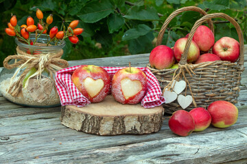 Rote Äpfel mit Herz rustikal auf Holz als Dekoration für den Herbst
