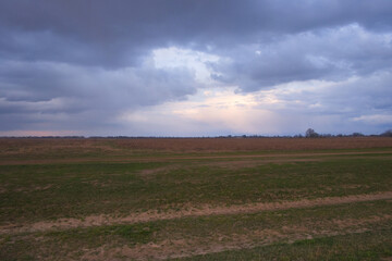 Dramatic pre-storm sky over the field. Spring landscape.