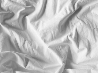 Wrinkle white cotton sheet image top view. Untidy bed cover after a good night sleep.