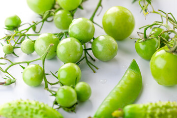 young green tomatoes, cucumbers and peas. Spiced vegetables. on white background.