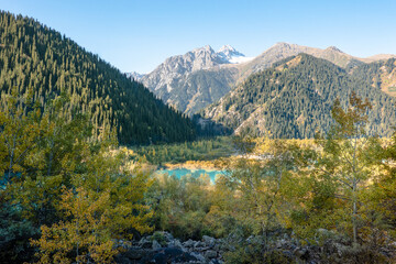 Fototapeta na wymiar Panorama of Tien Shan mountains, Issyk lake and autumn forest. Kazakhstan