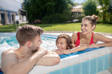 Fototapeta na wymiar Family spending time in the outdoor pool