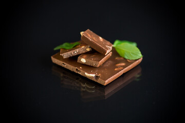 sweet dark chocolate with nuts on black background