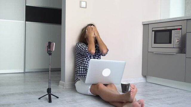 Woman with short hair in a plaid shirt works at home is experiencing a nervous breakdown