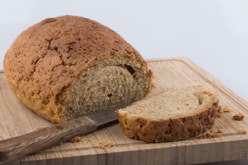 Well sliced loaf of bread on a cutting board with knife.