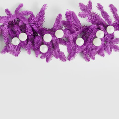 Holiday concept. purple spruce branches are decorated with white balls. copy space, flat lay, square frame