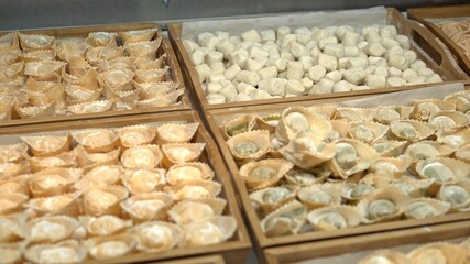 Raw italian food, ravioli, pasta on wooden trays at the italian restaurant kitchen, handmade italian food cooked. Different colour raw italian food for restaurant