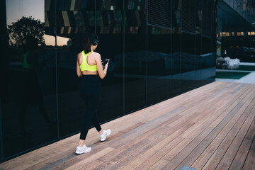 Fit woman using smartphone on street