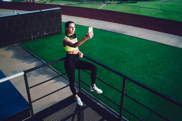 Fototapeta na wymiar Female runner taking selfie on smartphone