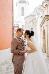 Happy young couple kissing on the background of old buildings.