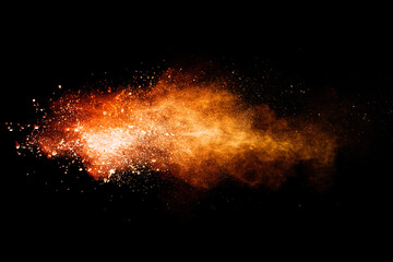 Fototapeta na wymiar Abstract orange powder explosion. Closeup of orange dust particle splash isolated on black background.