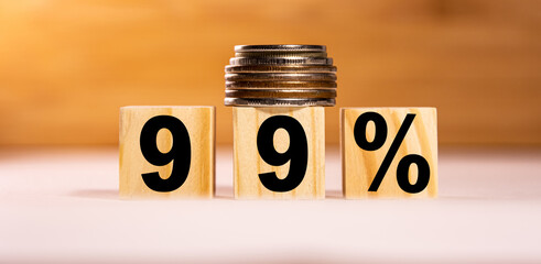 The concept of the word 99 percent on wooden cubes with coins on a white wooden background. Business concept.