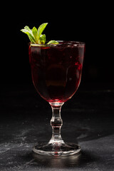 Glass of red wine sangria with mint leaves on black background
