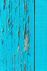Peeling blue paint on wood, close up.