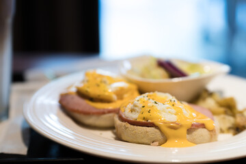 Weekend vegetarian breakfast in Scotland with two eggs benedict on homemade muffins with spinach and yellow hollandaise sauce.