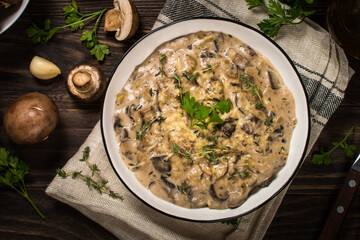 Champignons in cream sauce at white table.
