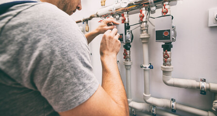 The man is installing the heater system in the house