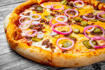 Pizza with Mozzarella cheese, Bolognese sauce, minced meat and vegetables. Italian pizza on wooden background.