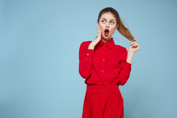 attractive woman in bright clothes on blue background gesturing with hands and red lips makeup cropped view emotions