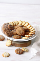 Group of Butter Cookies, on a white plate, on a white wooden table.
