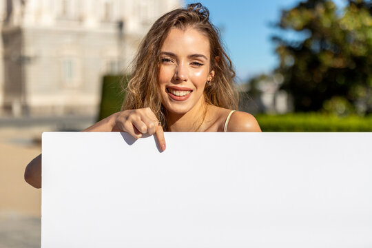 Modelo de publicidad posando con cartel en blanco, cartel para rellenar