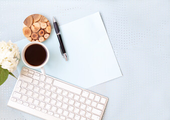 blue office desk background with smartphone with blank screen mockup, laptop computer, cup of coffee and supplies. Top view with copy space, flat lay.