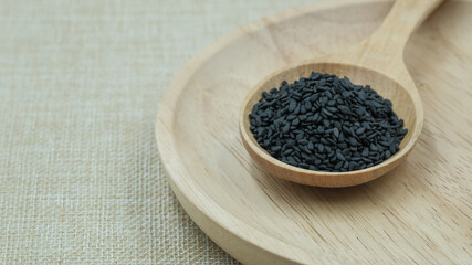 sesame paste with sesame seeds, black sesame seeds on sack cloth and wooden background.