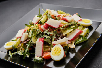 Crab stick salad with fresh vegetable and eggs.