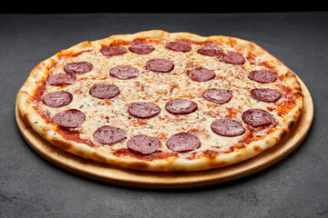 Delicious Italian Pizza pepperoni with mozzarella cheese and salami on dark background