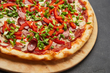 Pizza with a large number of toppings: hunting sausages, onions, cheese and bell pepper
